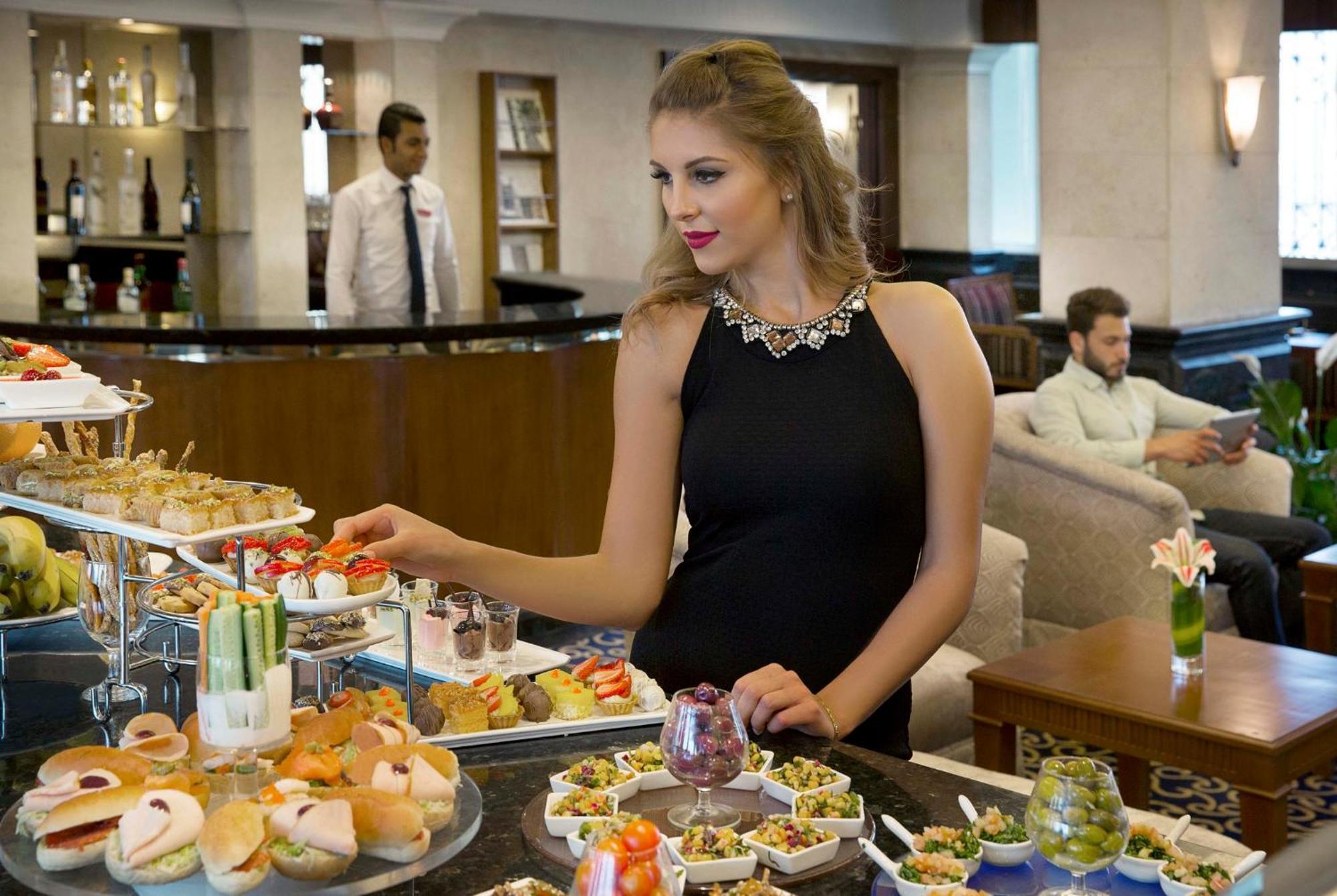Crowne Plaza Amman By Ihg Hotel Exterior foto A woman selecting food from a buffet
